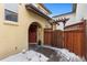 Neat front yard with wooden fence and snow-covered plants at 9624 Martin Luther King Blvd, Denver, CO 80238