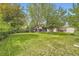 Well-maintained backyard with lush green grass, mature trees, and partial view of the home's exterior at 1462 S Dudley St, Lakewood, CO 80232