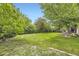 Expansive backyard featuring a lush lawn and mature trees, perfect for outdoor activities at 1462 S Dudley St, Lakewood, CO 80232