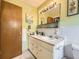 Bathroom features a wide vanity and a very large mirror with Hollywood lighting and mint green colored walls at 1462 S Dudley St, Lakewood, CO 80232