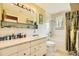 Bathroom with a combination tub and shower, wide vanity and large mirror with Hollywood lighting at 1462 S Dudley St, Lakewood, CO 80232