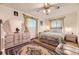 Bedroom with traditional decor, dresser with mirror, ceiling fan, and large patterned area rug at 1462 S Dudley St, Lakewood, CO 80232