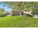 Landscaped front yard of a two-story home with mature tree and well-maintained lawn at 1462 S Dudley St, Lakewood, CO 80232