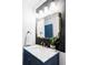 Bathroom featuring marble countertop, gold fixtures, elegant mirror, and navy blue cabinets at 1248 Ursula St, Aurora, CO 80011
