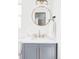 Stylish bathroom with modern fixtures, gray vanity, gold accents, and round mirror at 1248 Ursula St, Aurora, CO 80011