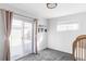 Bright bedroom featuring sliding glass doors, gray carpet, and ample natural light at 1248 Ursula St, Aurora, CO 80011