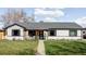 Charming single-story home features a well-manicured lawn and cozy covered porch seating area at 1248 Ursula St, Aurora, CO 80011