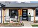 Inviting front porch with modern black door, sleek planters, and seating at 1248 Ursula St, Aurora, CO 80011