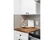 Modern kitchen featuring butcher block counters, decorative backsplash, and ample cabinet space at 1248 Ursula St, Aurora, CO 80011