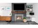 Living room featuring a brick fireplace, wood mantel, and modern shelving at 1248 Ursula St, Aurora, CO 80011