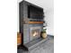 Brick fireplace with a wood mantel, television, and a cozy fire burning inside at 1248 Ursula St, Aurora, CO 80011