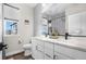 Well-lit bathroom boasts double sinks, modern fixtures, and stylish gray and white tiling at 21102 E Stanford Dr, Aurora, CO 80015
