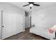 Bright bedroom features wood-look floors, a ceiling fan, and a closet with sliding doors at 21102 E Stanford Dr, Aurora, CO 80015
