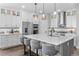 Bright kitchen featuring white cabinets, a gray tile backsplash, stainless steel appliances, and a large island with seating at 21102 E Stanford Dr, Aurora, CO 80015