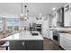 Modern kitchen with white cabinetry, gray accents, a large island with seating, and stainless steel appliances at 21102 E Stanford Dr, Aurora, CO 80015