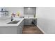 Basement kitchenette with modern gray cabinets, quartz countertops, and a wine fridge at 21102 E Stanford Dr, Aurora, CO 80015