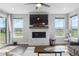 Bright living room with a stone fireplace, large windows offering scenic views, and a comfortable seating area at 21102 E Stanford Dr, Aurora, CO 80015