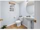 Cozy powder room featuring a pedestal sink, ceramic tile flooring, and a framed window at 4184 Netherland St, Denver, CO 80249