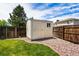 Backyard storage shed with a door and window, surrounded by rock bed and grass at 4184 Netherland St, Denver, CO 80249