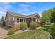 Side view of house with covered porch and lush green yard featuring mature landscaping at 21780 E Heritage Pkwy, Aurora, CO 80016