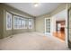Spacious bedroom with plush carpet, ample natural light from the bay window, and french doors at 21780 E Heritage Pkwy, Aurora, CO 80016