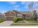 Charming ranch-style home with a well-manicured lawn, mature landscaping, and covered front porch at 21780 E Heritage Pkwy, Aurora, CO 80016