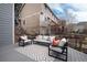 Open-air back deck offers ample seating with a sofa and chairs, plus scenic views of the natural landscape at 49 Dawn Heath Cir, Littleton, CO 80127
