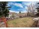 Spacious backyard featuring a lush lawn, mature trees, and partial views of neighboring homes at 49 Dawn Heath Cir, Littleton, CO 80127