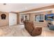 Basement living area with a comfortable brown sofa, television, and sliding glass doors to the outside at 49 Dawn Heath Cir, Littleton, CO 80127