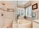 Updated bathroom featuring a glass-enclosed shower and soaking tub with natural light from shuttered windows at 49 Dawn Heath Cir, Littleton, CO 80127