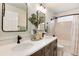 Bright bathroom with double vanity, modern fixtures, decorative mirror, and bathtub with tiled walls at 49 Dawn Heath Cir, Littleton, CO 80127