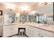 Luxurious bathroom featuring dual sinks, granite countertops, and a vanity area, complemented by tile flooring at 49 Dawn Heath Cir, Littleton, CO 80127