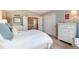 Bright bedroom with a white comforter, dual closets, and light-filled ensuite bathroom at 49 Dawn Heath Cir, Littleton, CO 80127