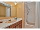 Bathroom with shower/tub combo and wood vanity at 9233 W Virginia Dr, Lakewood, CO 80226