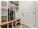 Functional mud room featuring storage benches, shelves, a beverage cooler, and decorative hooks at 8937 Red Bud St, Parker, CO 80134