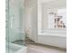 Bathroom showcasing glass door shower, soaking tub, and bright window at 4716 Twelve Oaks Way, Castle Rock, CO 80104