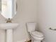 Elegant powder room featuring pedestal sink, oval mirror, and updated fixtures at 4716 Twelve Oaks Way, Castle Rock, CO 80104