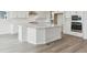 Elegant kitchen island featuring white cabinetry, stainless steel appliances, and plank flooring at 4716 Twelve Oaks Way, Castle Rock, CO 80104