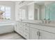 Bathroom featuring double sink vanity, large mirror, and tub with tile surround at 4716 Twelve Oaks Way, Castle Rock, CO 80104
