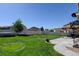 Large backyard featuring green lawn, privacy fence, patio area with pergola, and trampoline at 11158 Carbondale St, Firestone, CO 80504