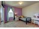 Bright bedroom featuring purple accent wall, plush carpet, and cozy twin bed and a window with natural light at 11158 Carbondale St, Firestone, CO 80504