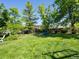 Spacious backyard with mature trees, landscaped garden beds, and a cozy hammock area for relaxation at 21351 E Williamette Pl, Centennial, CO 80015