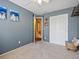 Bedroom featuring a closet, a seating bench, neutral carpet, and blue accent wall at 21351 E Williamette Pl, Centennial, CO 80015