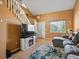Comfortable living room with stairs, large TV with fireplace, and lots of natural light at 21351 E Williamette Pl, Centennial, CO 80015