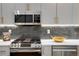 Modern kitchen with stainless steel appliances and stylish backsplash tiles at 5148 W 44Th Ave, Denver, CO 80212
