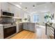 Modern kitchen with stainless steel appliances, sleek cabinets, and an adjacent living area with great natural light at 5148 W 44Th Ave, Denver, CO 80212