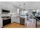 Open-concept kitchen with stainless steel appliances, quartz countertops, and modern pendant lighting perfect for entertaining at 5148 W 44Th Ave, Denver, CO 80212