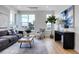Bright living room boasts large windows, light wood floors, modern furniture, and an open floor plan at 5148 W 44Th Ave, Denver, CO 80212