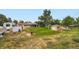 Large backyard with a grassy area, a fire pit, two sheds, and a camper parked on the property at 4244 W Monmouth Ave, Littleton, CO 80123
