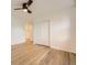 Bright bedroom features hardwood floors, ceiling fan, and closet with white sliding doors at 4244 W Monmouth Ave, Littleton, CO 80123